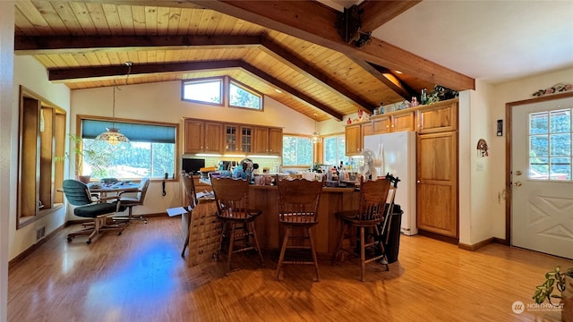 kitchen with white refrigerator, a breakfast bar area, kitchen peninsula, light hardwood / wood-style flooring, and vaulted ceiling with beams