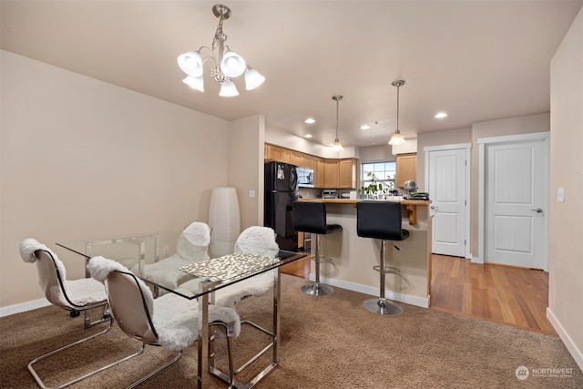 dining space with a notable chandelier and light hardwood / wood-style flooring