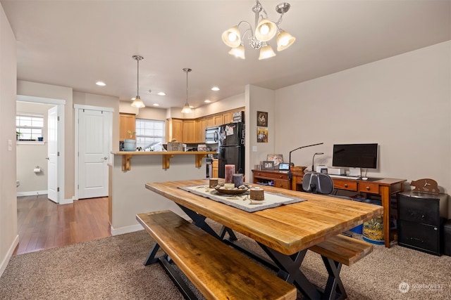 dining area with dark hardwood / wood-style floors and an inviting chandelier