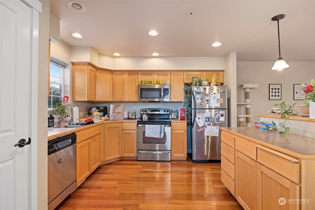 kitchen featuring light brown cabinets, stainless steel appliances, and light hardwood / wood-style floors