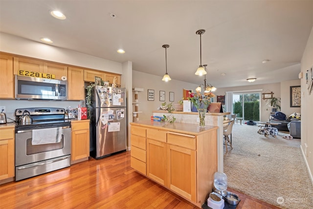 kitchen with stainless steel appliances, light hardwood / wood-style floors, pendant lighting, and light brown cabinets