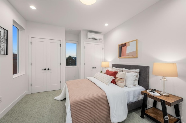 carpeted bedroom with multiple closets and a wall mounted air conditioner