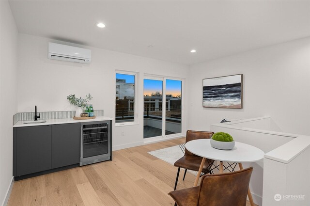 interior space featuring beverage cooler, light hardwood / wood-style floors, indoor wet bar, and an AC wall unit