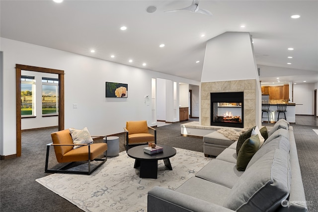 living room featuring lofted ceiling, a fireplace, and carpet flooring