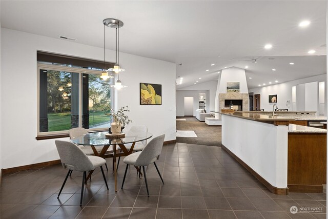 tiled dining area with a multi sided fireplace, vaulted ceiling, and a chandelier