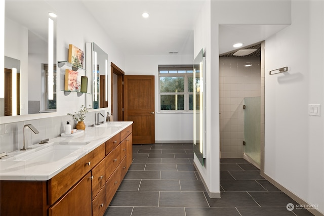 bathroom featuring a tile shower, tile patterned flooring, and vanity