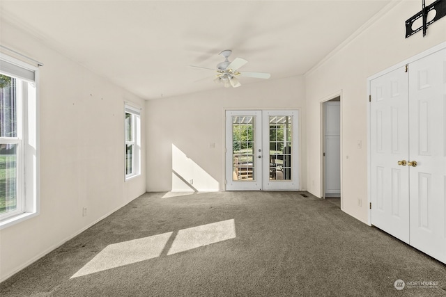 interior space featuring carpet flooring, vaulted ceiling, crown molding, ceiling fan, and french doors