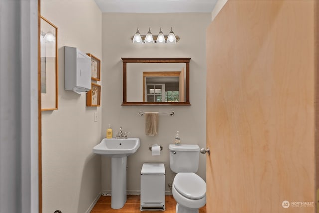 bathroom featuring sink, hardwood / wood-style floors, and toilet