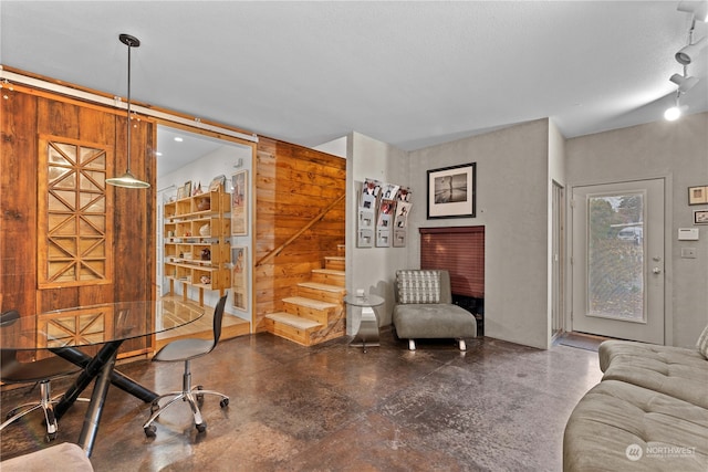 interior space with wooden walls, concrete floors, and a textured ceiling