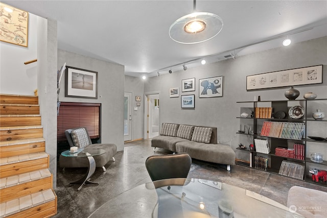 living room with concrete flooring and rail lighting