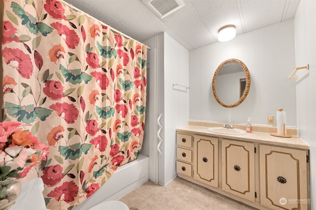 full bathroom featuring vanity, shower / bath combination with curtain, tile patterned flooring, toilet, and a textured ceiling