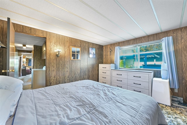 carpeted bedroom featuring wooden walls and a textured ceiling