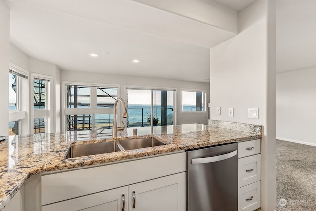 kitchen featuring a wealth of natural light, carpet flooring, a water view, and dishwasher