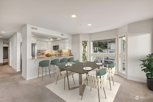 carpeted dining area featuring sink