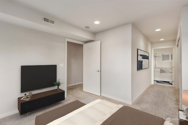 interior space with light colored carpet and ensuite bath