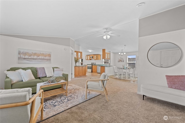 carpeted living room with ceiling fan with notable chandelier and lofted ceiling