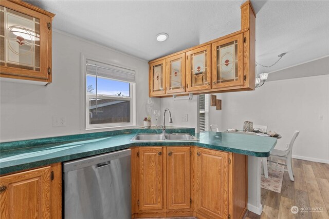 kitchen featuring kitchen peninsula, dishwasher, light wood-type flooring, sink, and a notable chandelier