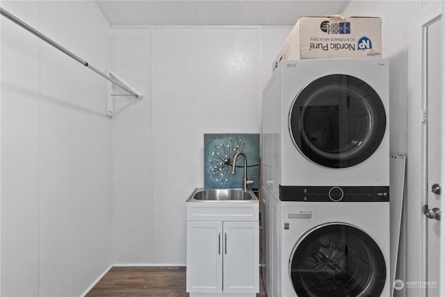 clothes washing area featuring cabinets, dark hardwood / wood-style flooring, sink, and stacked washing maching and dryer