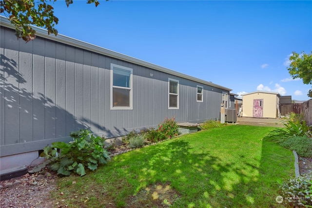 view of side of home with a yard and central air condition unit