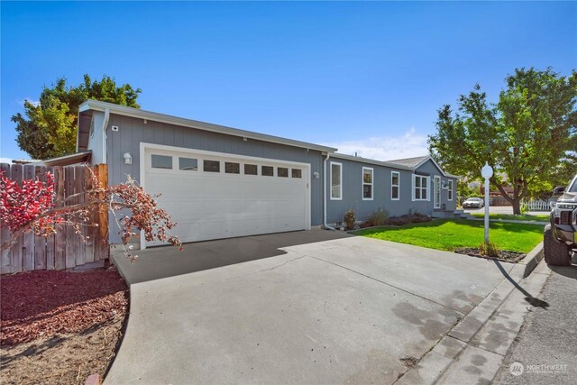 ranch-style home with a garage and a front yard