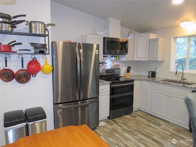 kitchen featuring sink, light hardwood / wood-style flooring, stainless steel appliances, and white cabinets