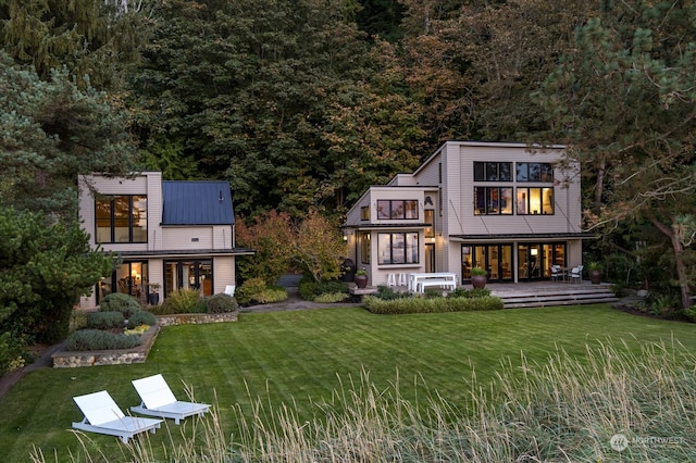 rear view of property featuring metal roof and a yard