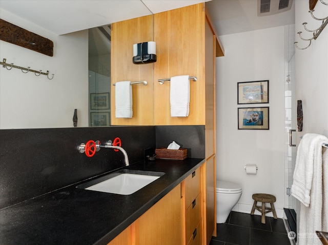 bathroom featuring vanity, a shower with shower door, visible vents, tile patterned floors, and toilet