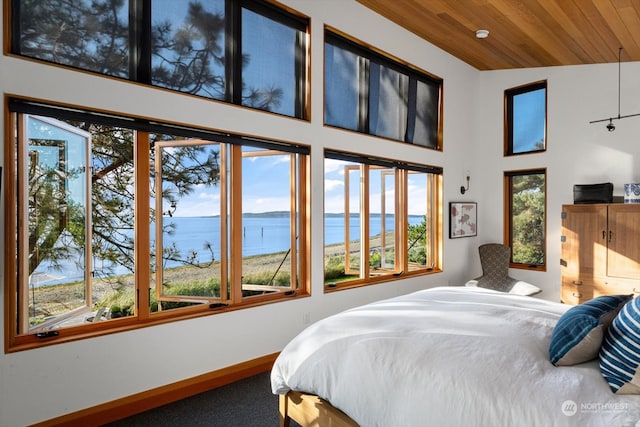 bedroom with baseboards, a water view, wood ceiling, and carpet flooring