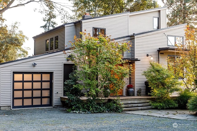 view of front of house with gravel driveway and a garage