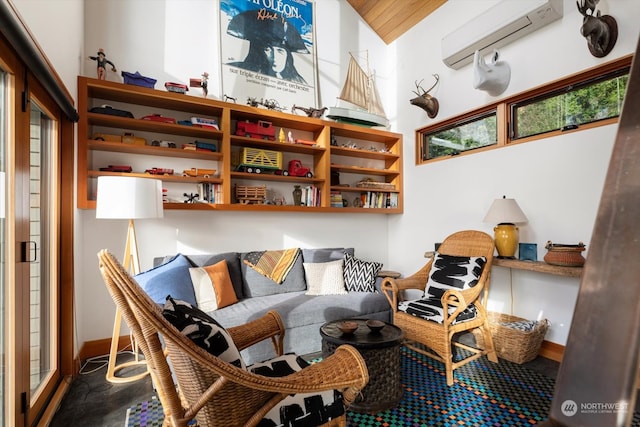 sitting room with an AC wall unit and baseboards