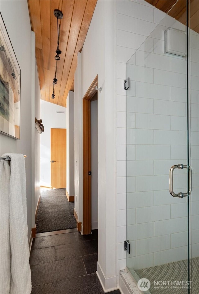 bathroom featuring a shower stall, wood ceiling, and baseboards