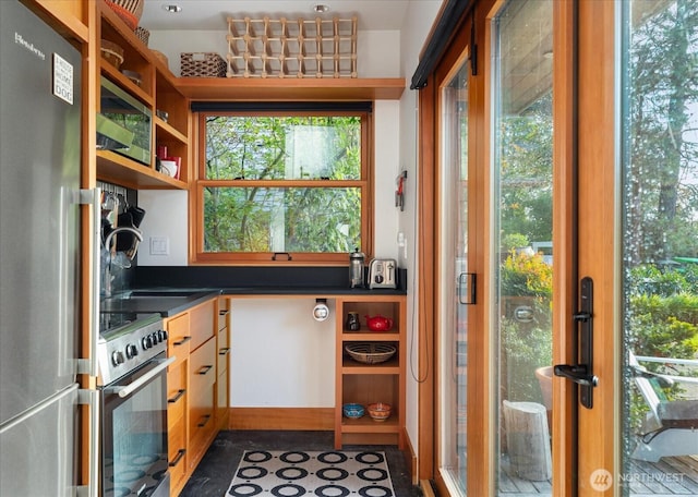 kitchen with dark countertops, appliances with stainless steel finishes, and open shelves