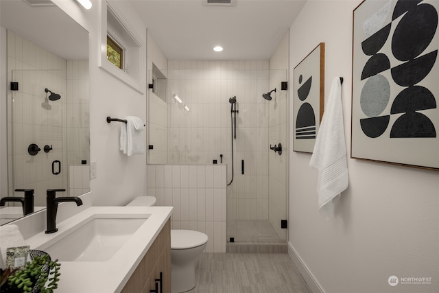 bathroom featuring vanity, toilet, and an enclosed shower