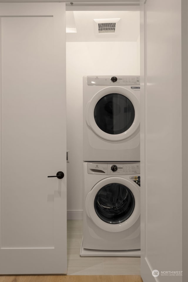 clothes washing area featuring stacked washer / dryer