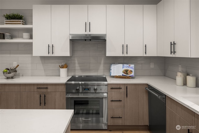 kitchen featuring white cabinetry, stainless steel range, black dishwasher, light stone counters, and decorative backsplash