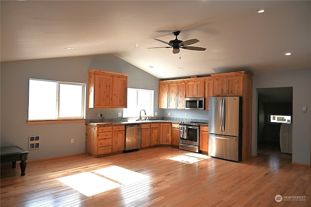 kitchen featuring stainless steel appliances, lofted ceiling, sink, ceiling fan, and light wood-type flooring