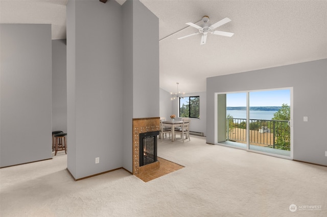 living room with a fireplace, ceiling fan with notable chandelier, a textured ceiling, a water view, and light colored carpet