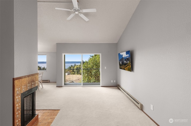 carpeted living room with lofted ceiling, a tiled fireplace, ceiling fan, a textured ceiling, and baseboard heating