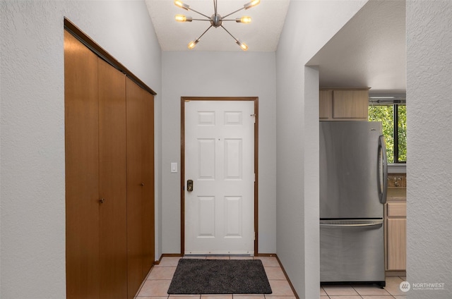 entryway featuring a textured ceiling, light tile patterned flooring, and vaulted ceiling