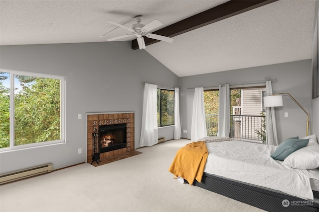 carpeted bedroom featuring ceiling fan, multiple windows, vaulted ceiling with beams, and a tile fireplace