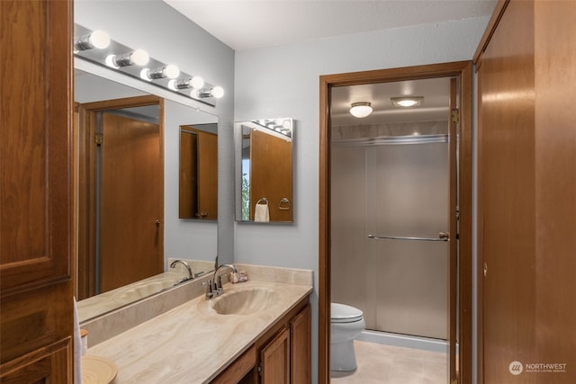 bathroom with vanity, tile patterned floors, toilet, and walk in shower