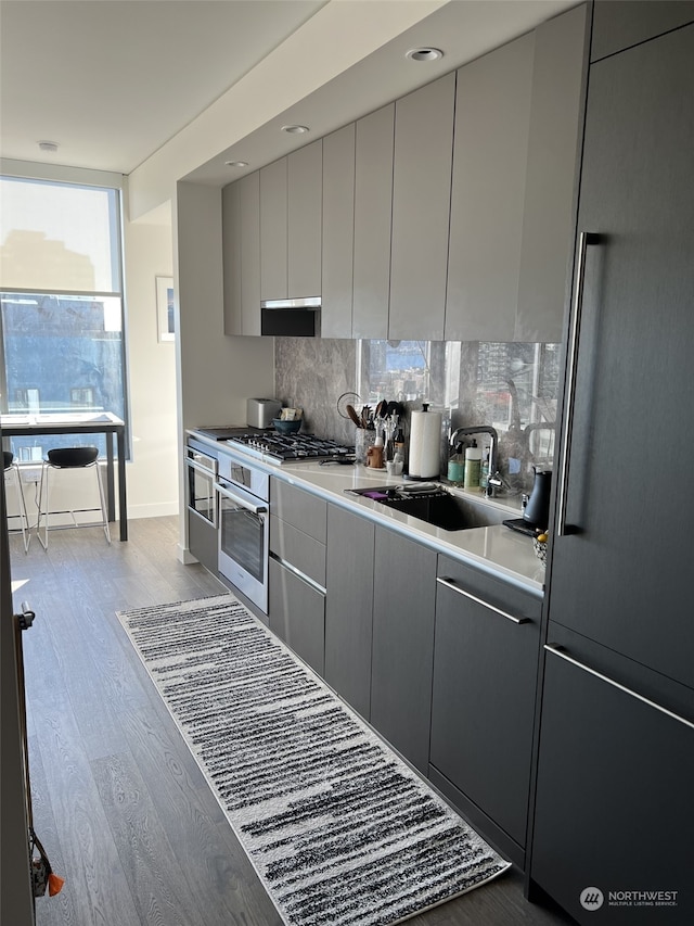 kitchen featuring fridge, decorative backsplash, light hardwood / wood-style floors, and gray cabinets