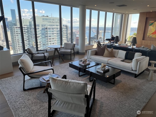 living room featuring a wealth of natural light, a water view, and hardwood / wood-style floors