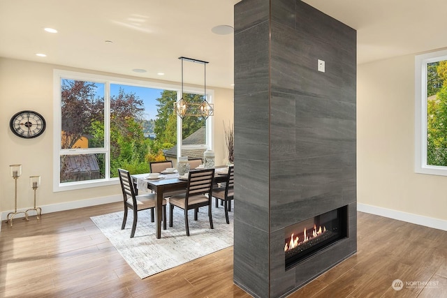 dining room featuring wood finished floors, recessed lighting, baseboards, and a notable chandelier
