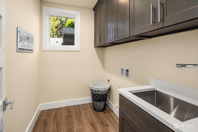 laundry room featuring dark wood-type flooring, hookup for an electric dryer, washer hookup, baseboards, and cabinet space