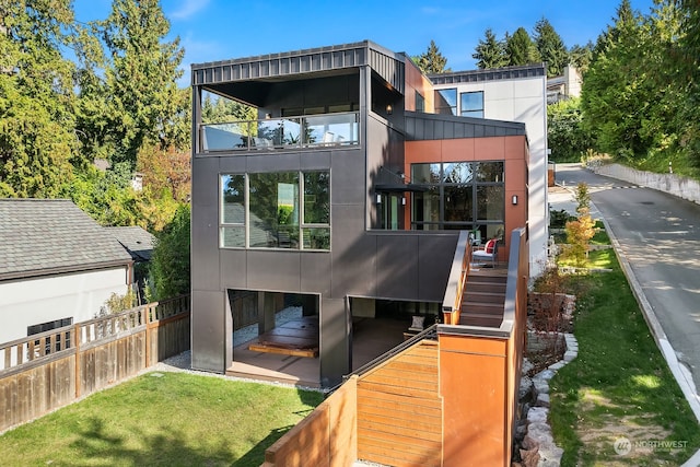 rear view of property featuring a lawn