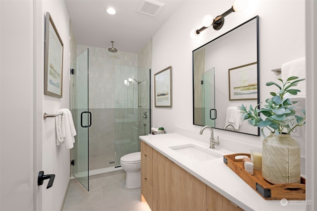 bathroom featuring tile patterned floors, a shower with door, vanity, and toilet