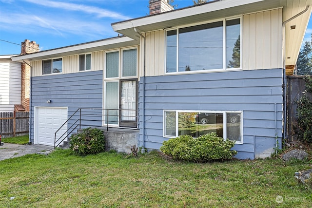 view of side of property with a lawn and a garage