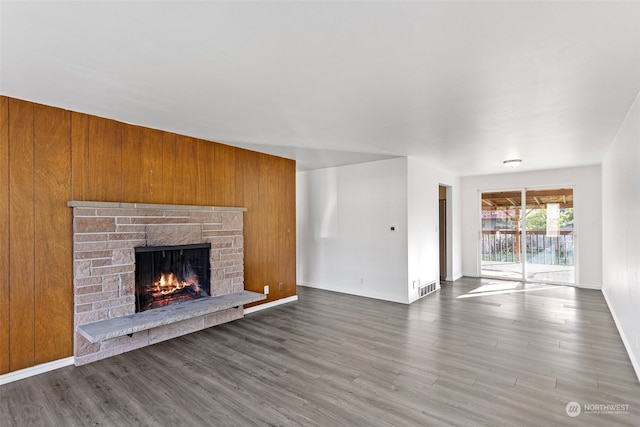 unfurnished living room featuring wood walls and dark hardwood / wood-style floors