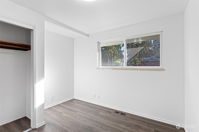 unfurnished bedroom featuring a closet and hardwood / wood-style flooring